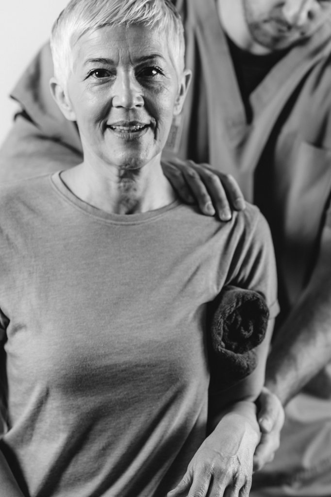 Therapist Checking Senior Woman’s Shoulder
